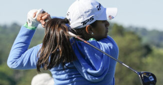 A close up of Megha Ganne as she follows through on a drive. She faces toward the right and the club is in the finished position on her shoulders.