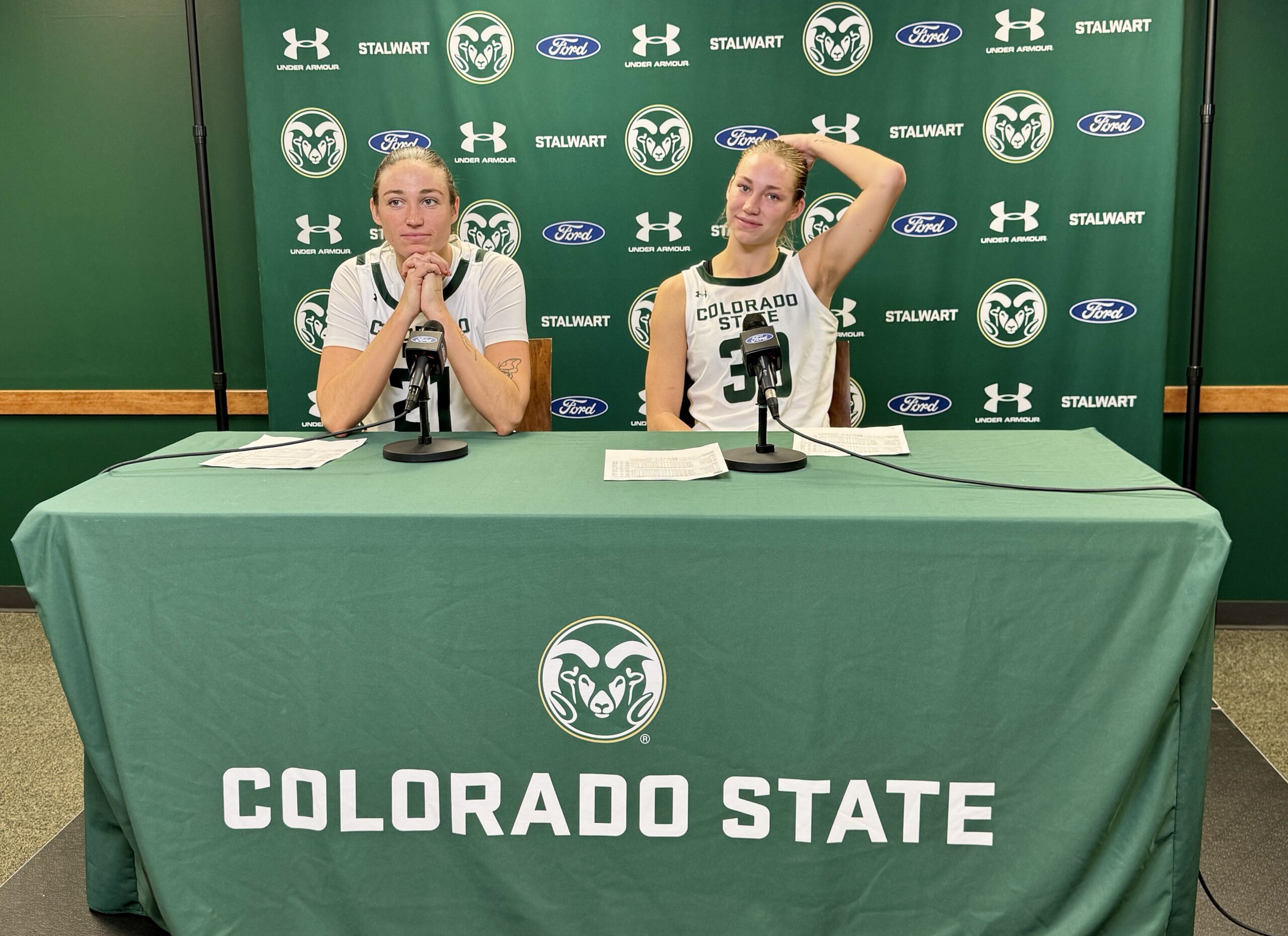 Two Colorado State basketball players sit at a table waiting to answer questions from the media after CSU's game against San Diego State.