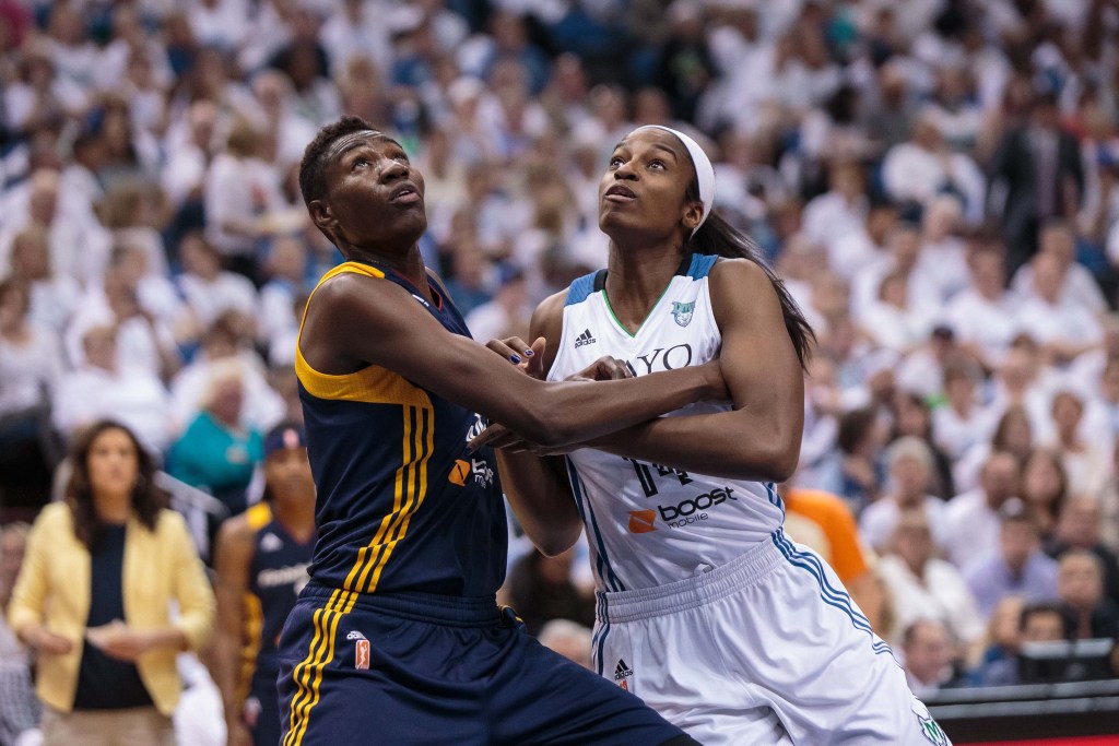Indiana Fever forward Natasha Howard and Minnesota Lynx forward Devereaux Peters battle for position as they look up at the flight of the ball.