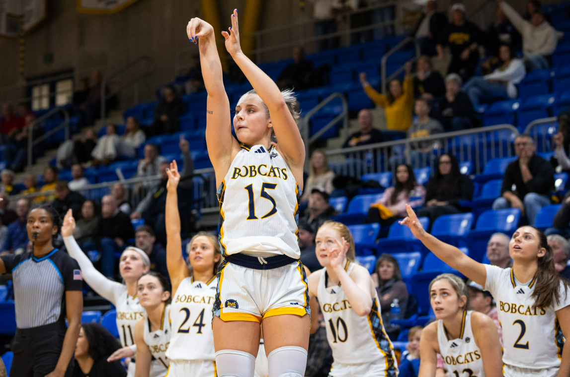 Quinnipiac guard Karson Martin (center) follows through a shot with her right hand while she concentrates toward the basket.