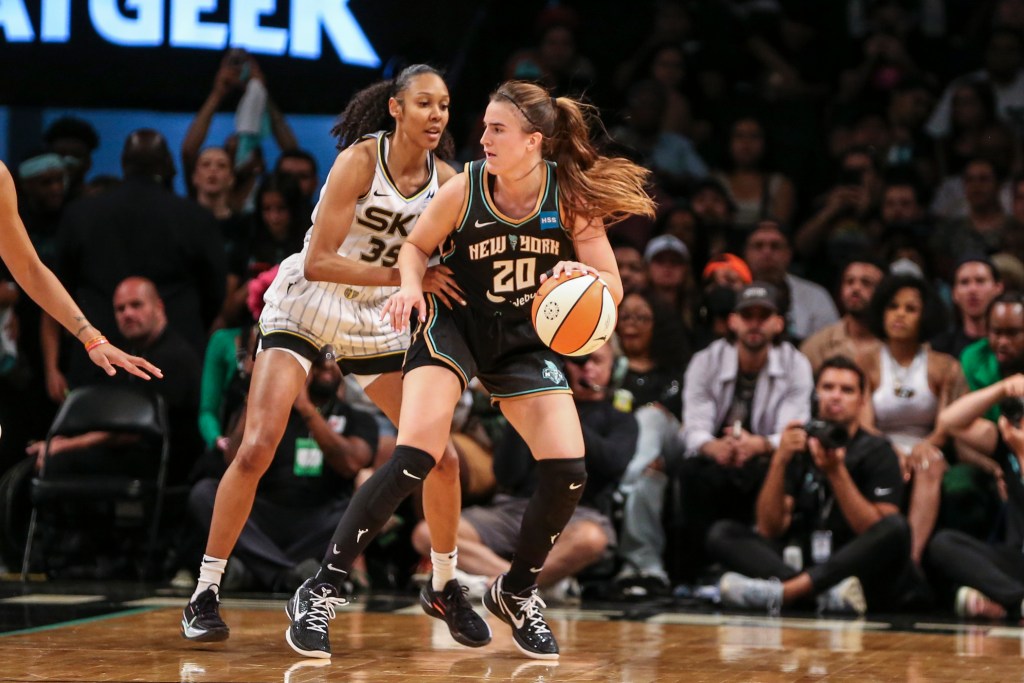 Sabrina Ionescu backs into Rebekah Gardner on the court.