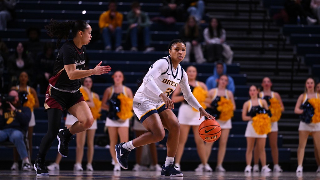 Drexel's Amaris Baker dribbles the ball with her left hand and looks up the court. An opposing player runs back down the court next to her.