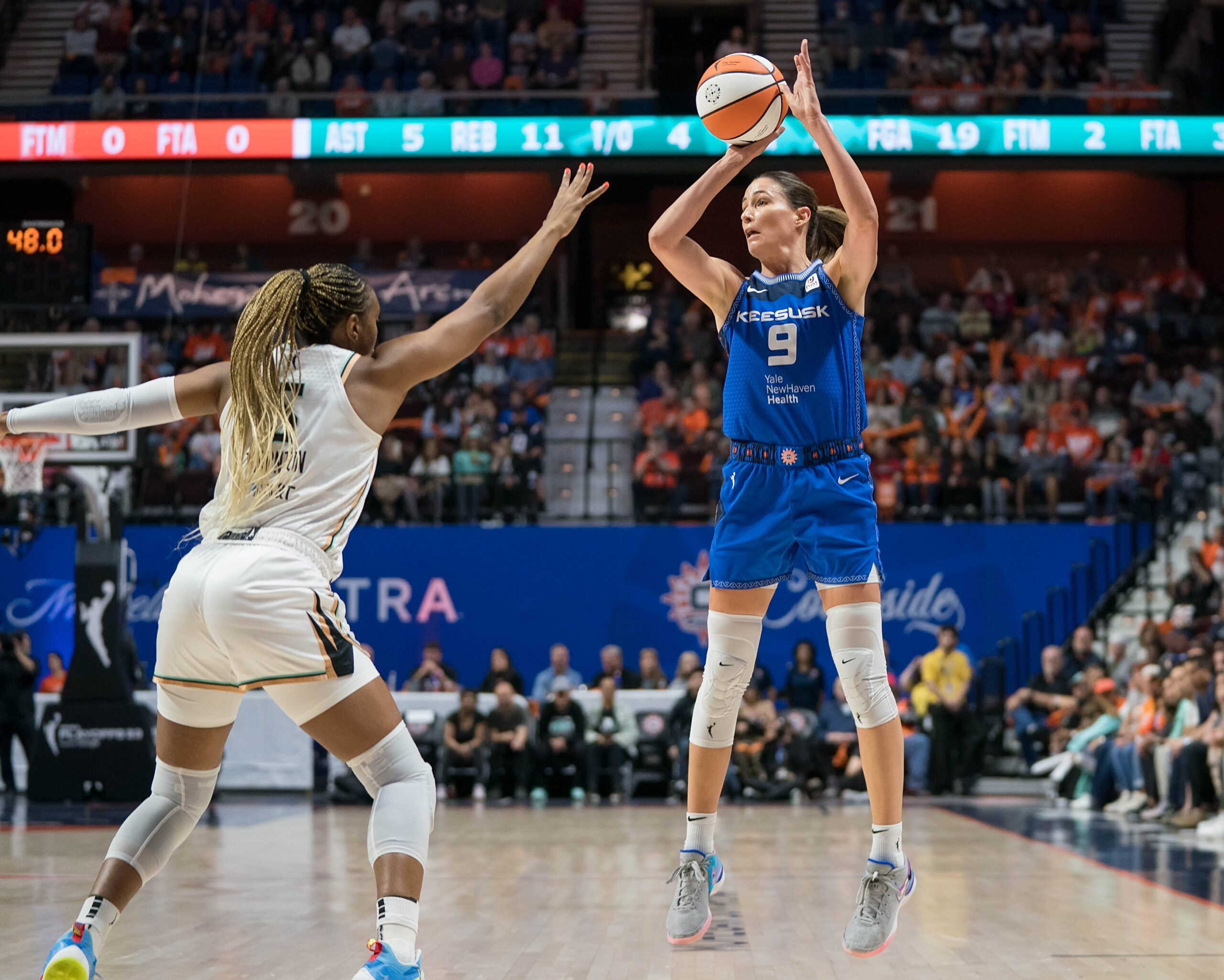 Connecticut Sun guard Rebecca Allen raises up and shoots the ball while New York Liberty guard Kayla Thornton raises her right hand