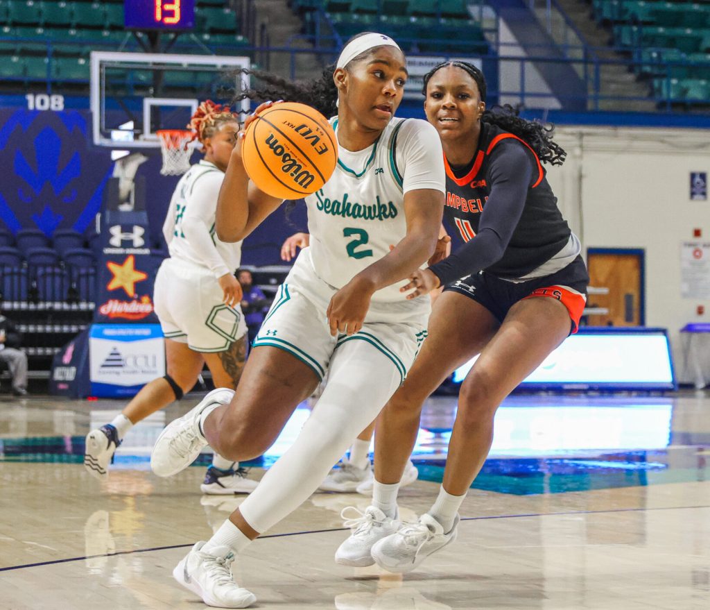UNCW's Taylor Henderson drives to the basket against Campbell's Olivia Tucker in a game earlier this season. (Photo credit: Nathan Hovey | UNCW Athletics)