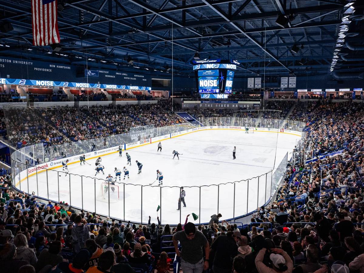 A shot taken from the top corner of the concourse, showing packed stands and the players lining up for a faceoff.