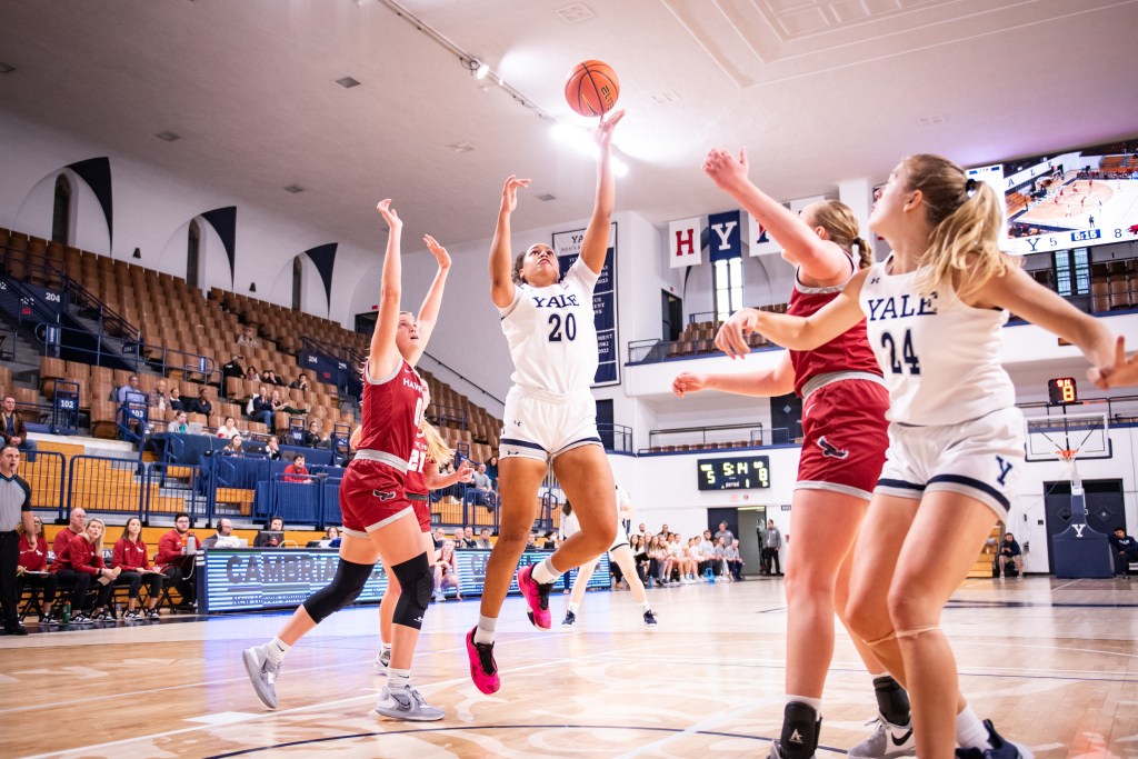 Yale forward Grace Thybulle shoots an open left-handed floater in the paint. Teammate Mackenzie Egger watches the ball go up and positions herself down low and facing the basket.