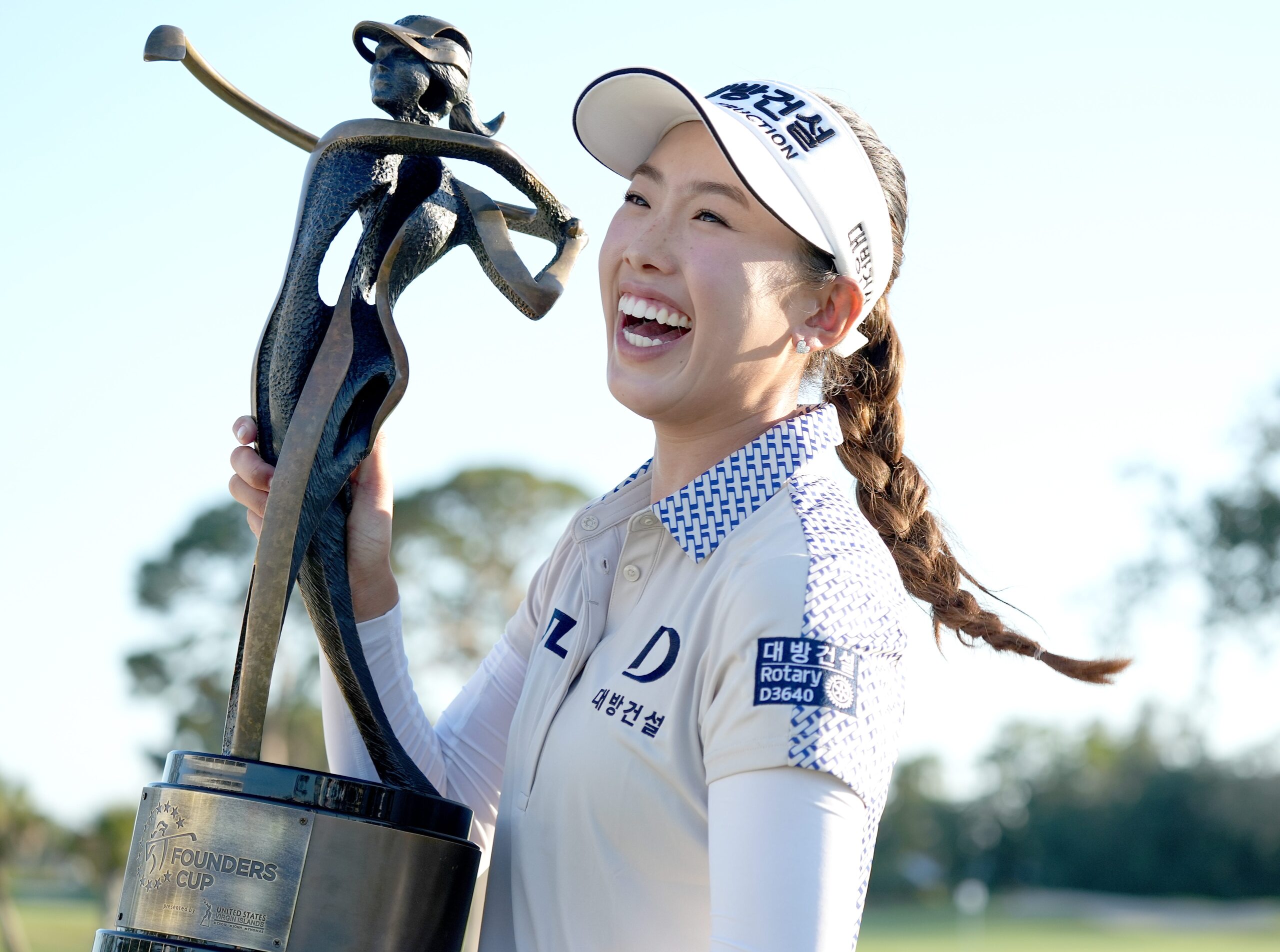 Yealimi Noh holds up the Founders Cup trophy to her right side while smiling broadly.