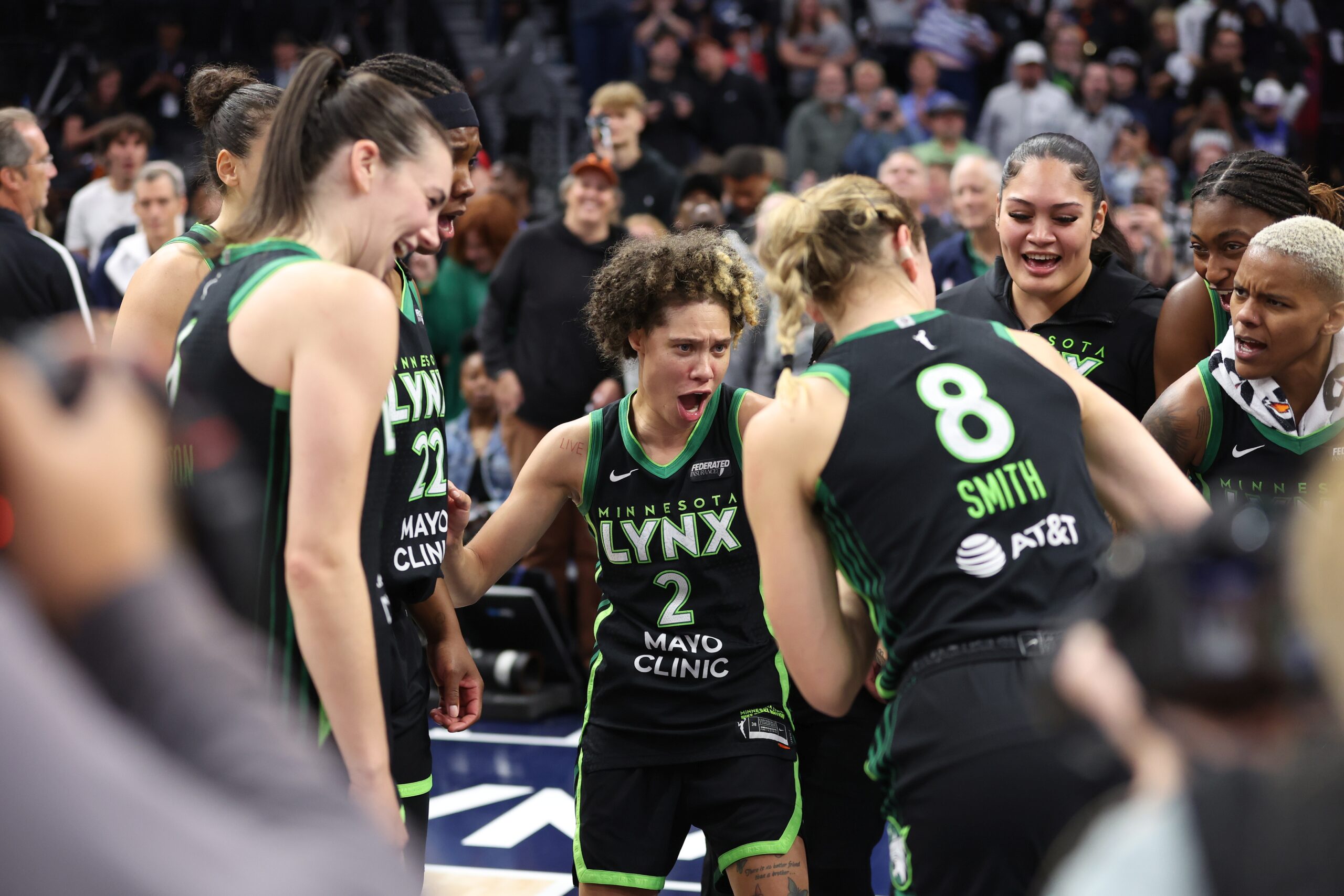 Minnesota Lynx guard Natisha Hiedeman celebrates with her teammates, including Bridget Carleton and Alanna Smith, after winning a WNBA playoff series.