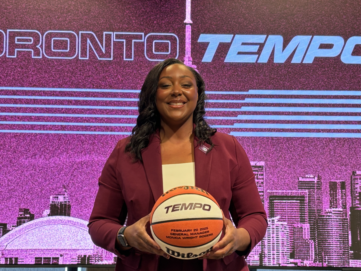 Monica Wright Rogers holding a basketball at a Toronto Tempo press conference.