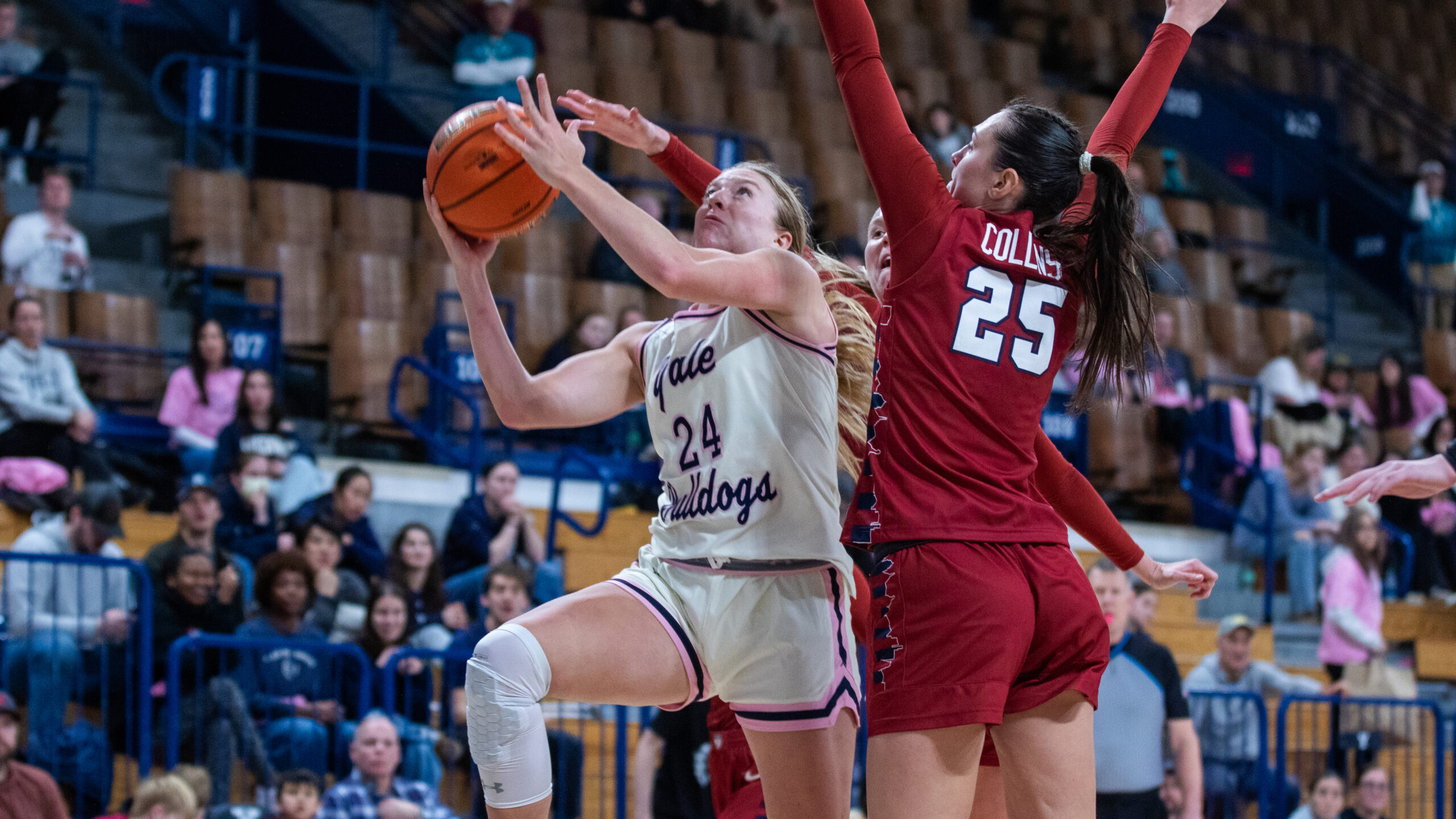 Yale forward Mackenzie Egger rises to shoot a right-handed shot as one Penn defender walls up and another tries to block the shot from behind.