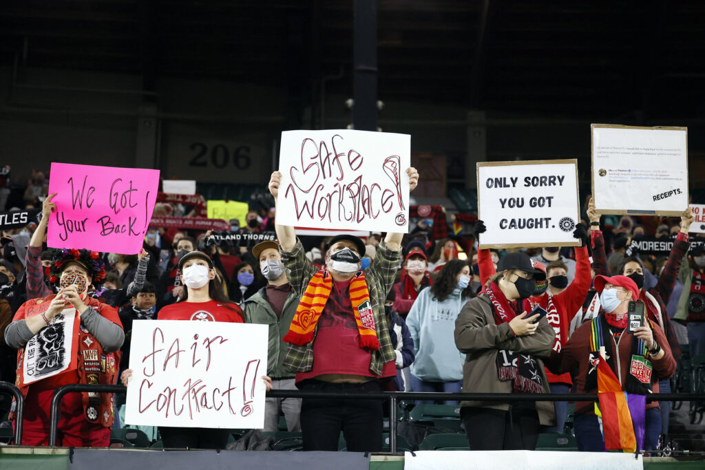 Fans hold signs during an NWSL soccer match at Providence Park in Portland, Oregon. (Photo credit: Soobum Im | USA TODAY Sports)
