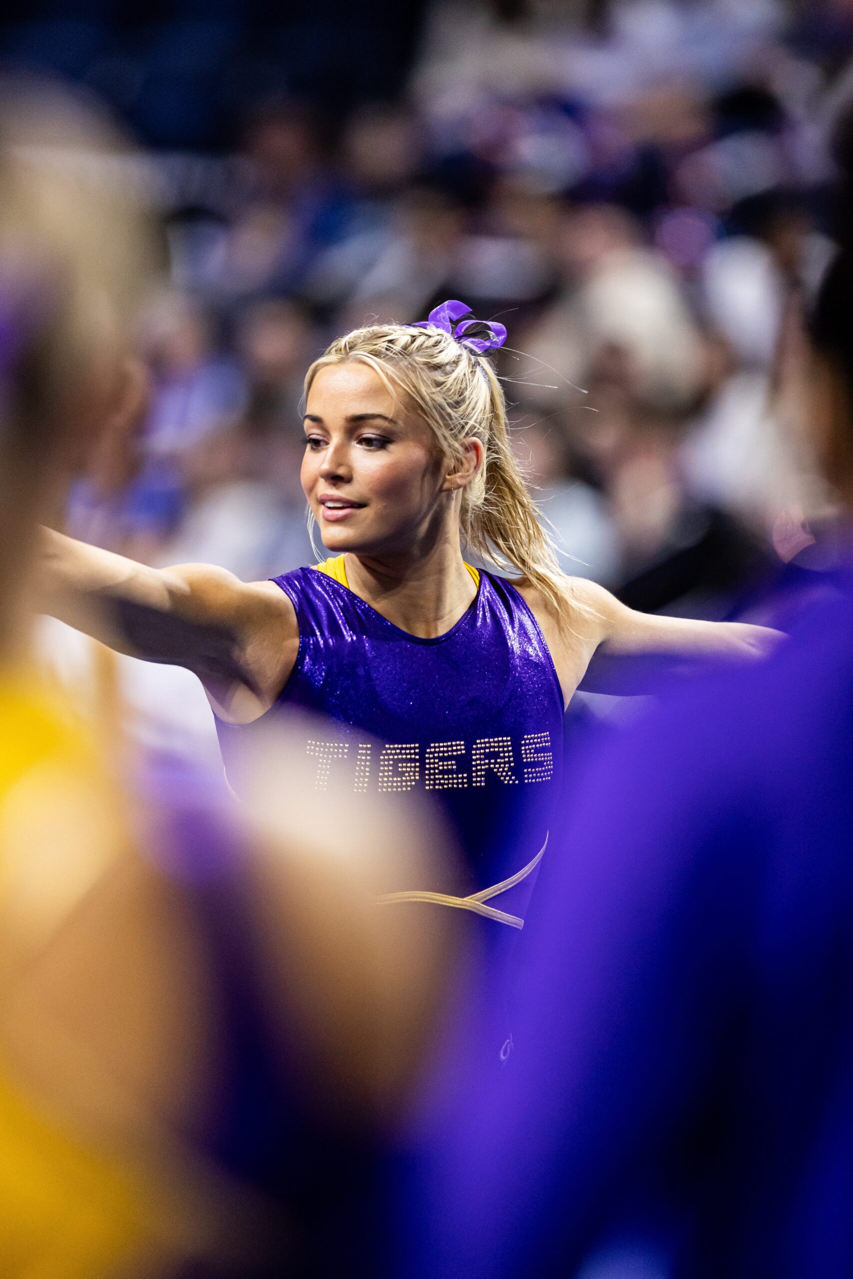 Olivia Dunne, in a purple leotard, warms up before a meet.