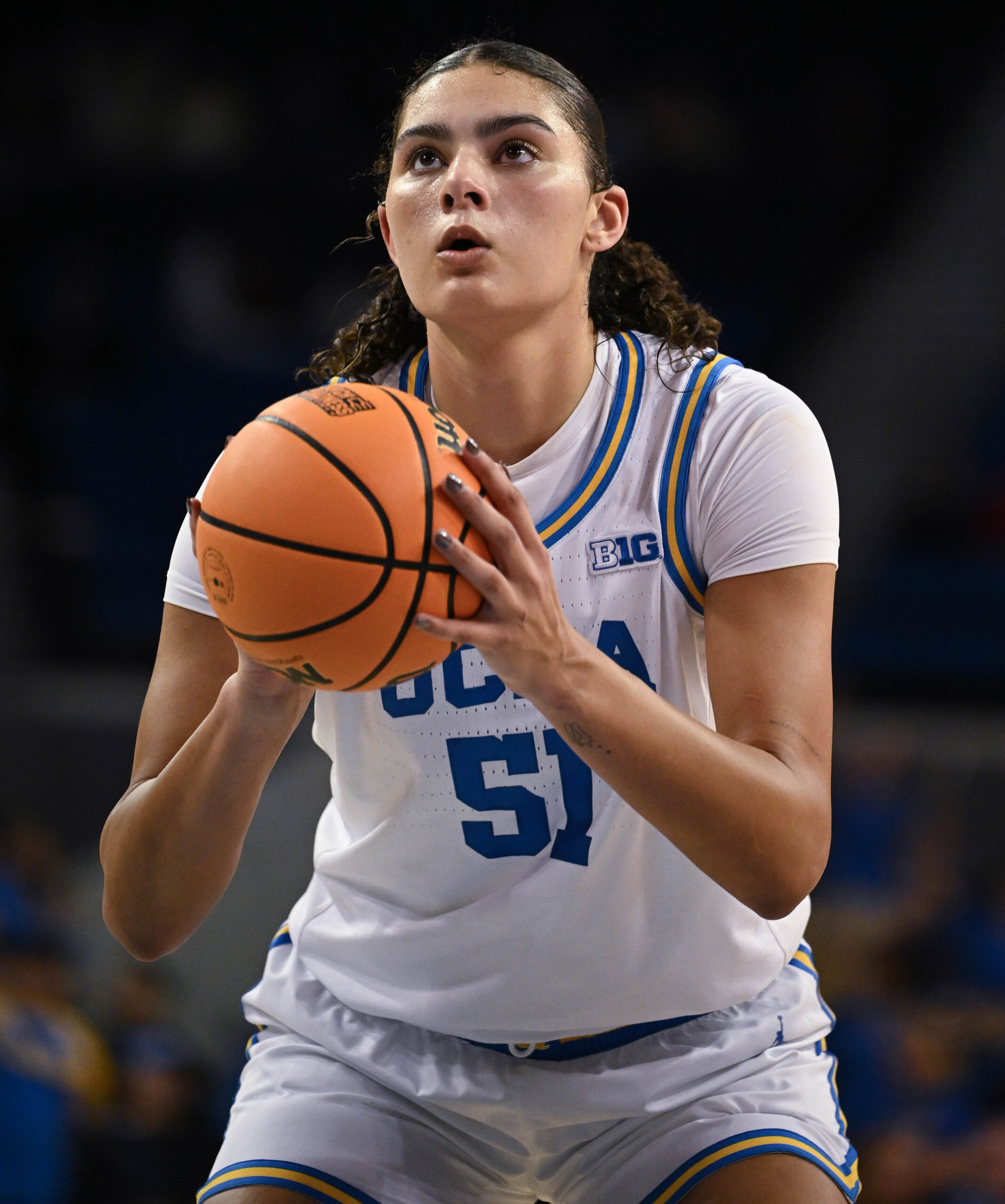 Lauren Betts, wearing a white UCLA uniform, shoots a free throw.