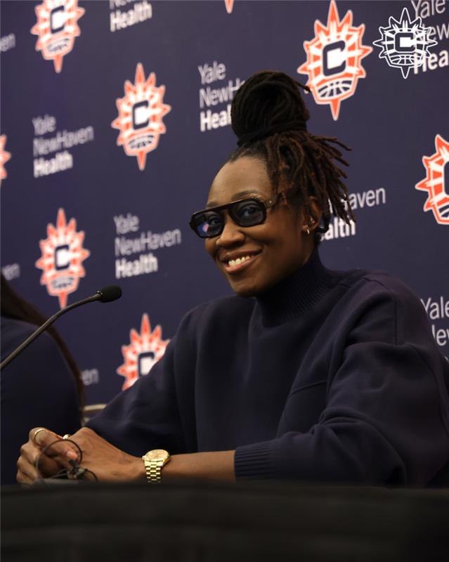Tina Charles, smiling at podium.