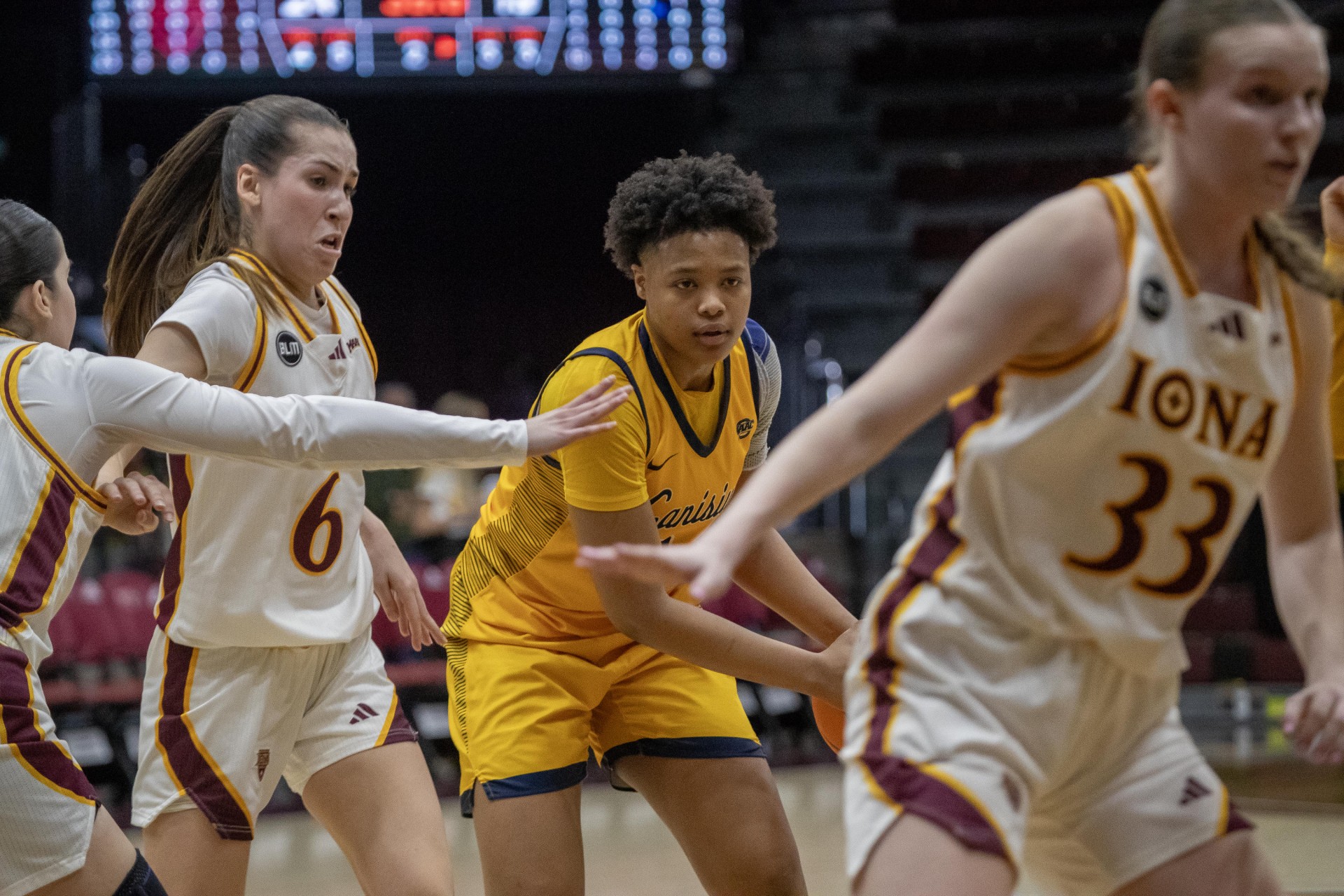Canisius' sophomore forward Shariah Gailes (in yellow) looks toward the basket to pass the basketball. (Photo credit: Joe Lehrman).