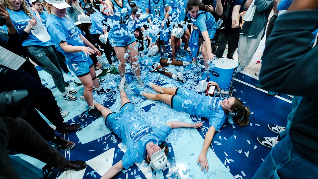 Columbia co-captains Cecelia Collins and Kitty Henderson lie on the court and spread their arms to make 'snow angels' in the light blue confetti.