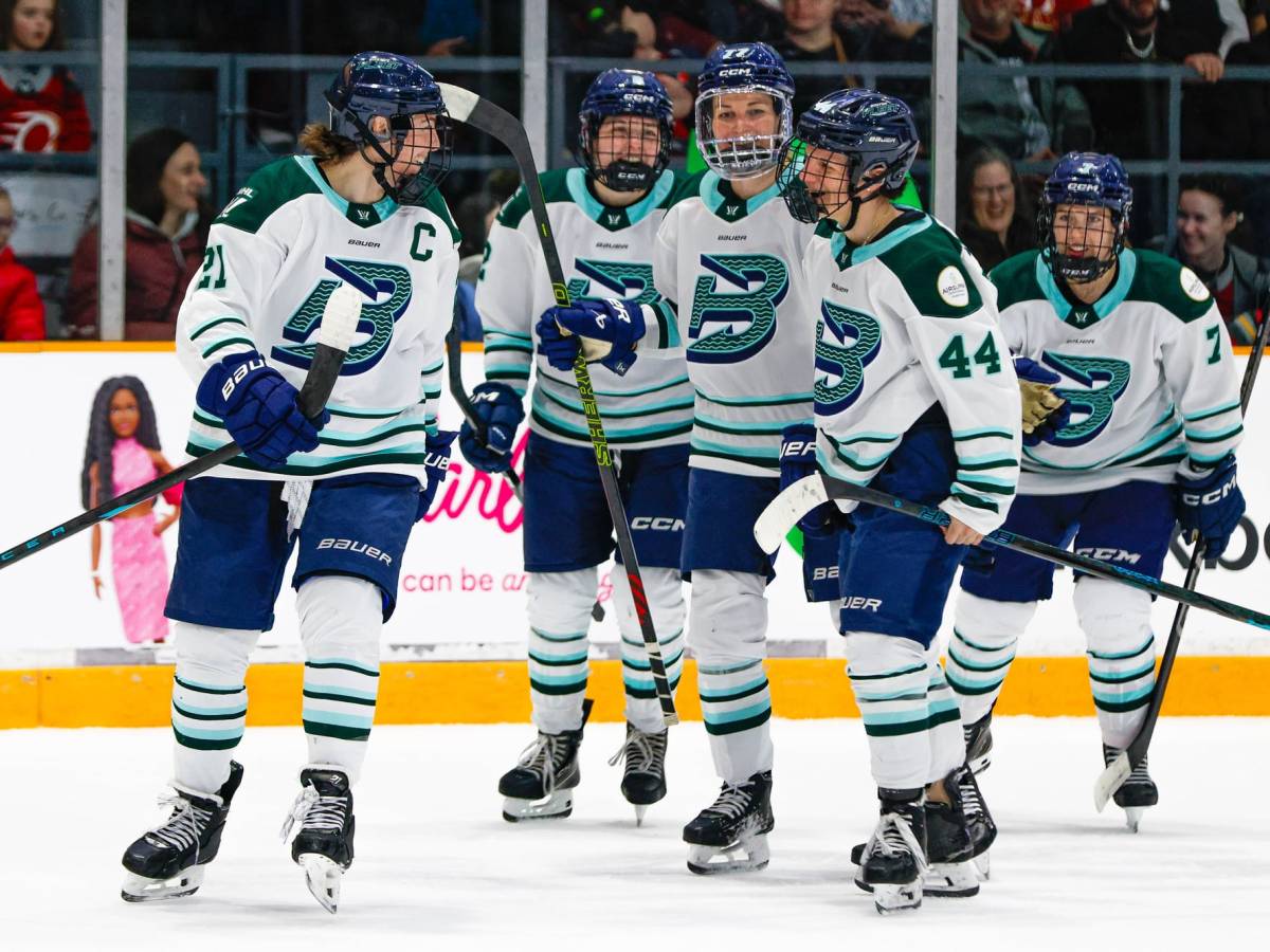 Five Fleet players smile after just breaking a group hug. They're wearing white away uniforms.