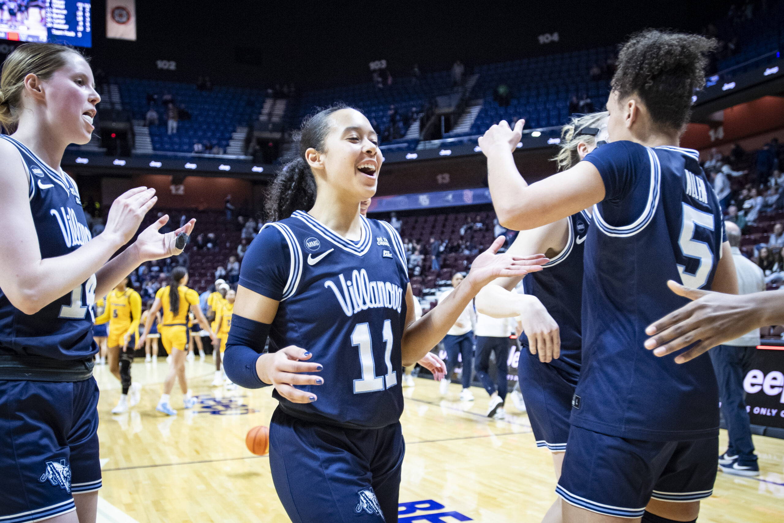 Jasmine Bascoe smiles and celebrates with teammates