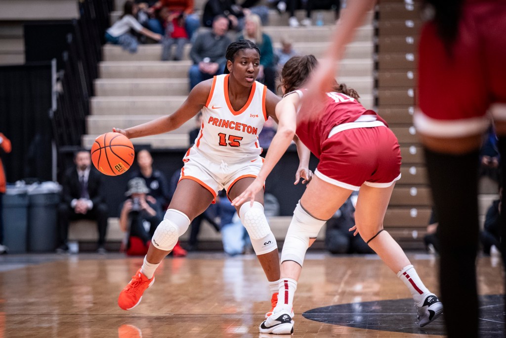 Princeton guard/forward Fadima Tall dribbles the ball with her right hand as Harvard guard/forward Elena Rodriguez defends her tightly.