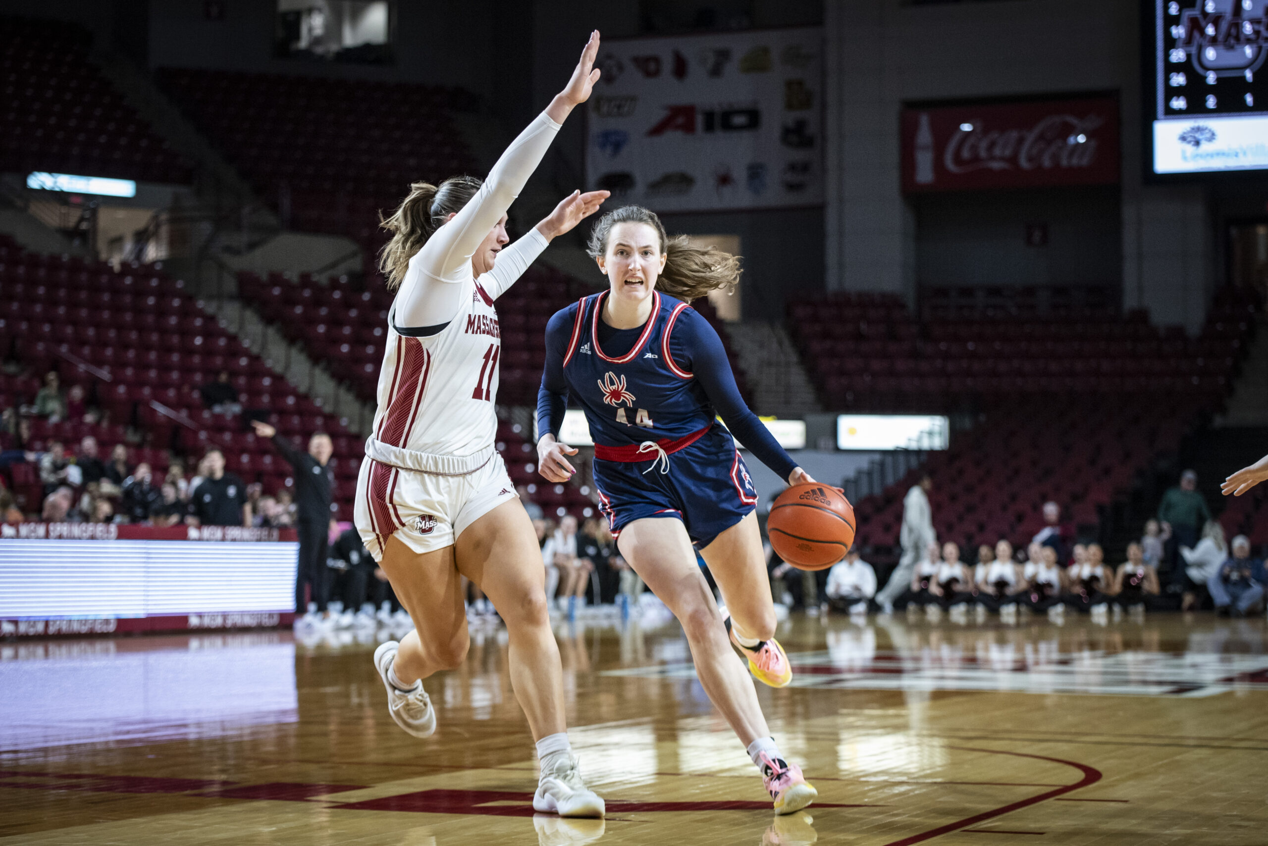 Richmond junior forward Maggie Doogan dribbles the ball down the lane with her left hand as she heads towards the basket. She looks to go around the defender.