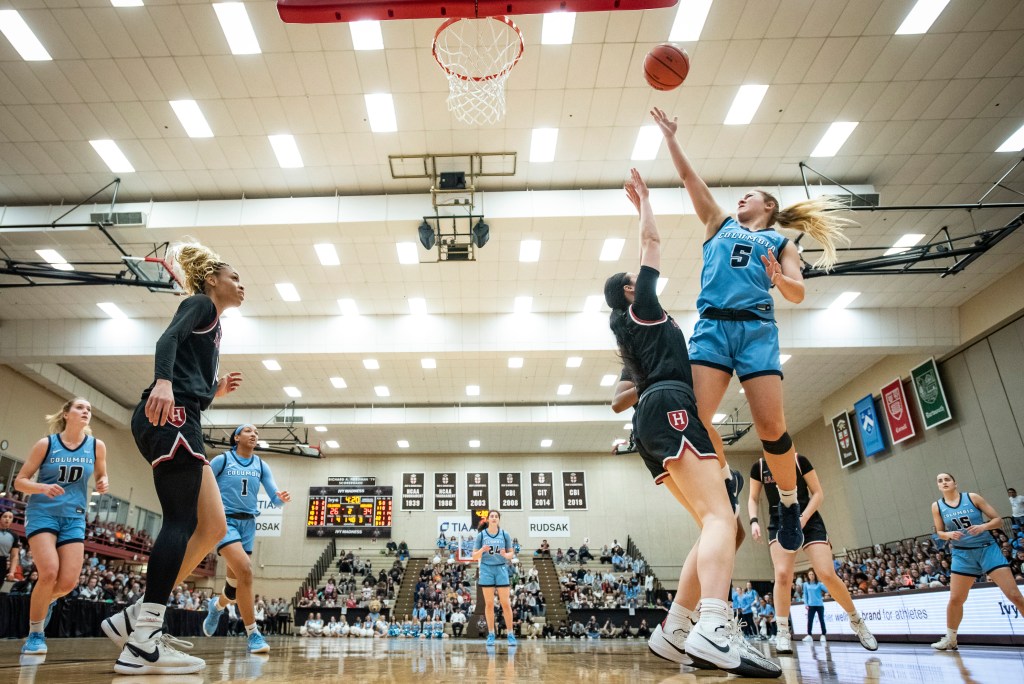 Columbia guard Mia Broom shoots a right-handed layup on the left side of the rim as a Harvard defender stands straight up to contest it.