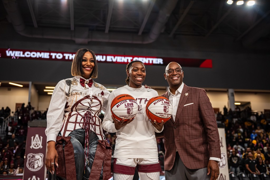 Alisha Wilson was honored earlier this year for scoring 1,000 career points and grabbing 1,000 career rebounds for her career and she's flanked by head coach Dawn Thornton and athletic director Paul Bryant. (Photo credit: Alabama A&M Athletics)