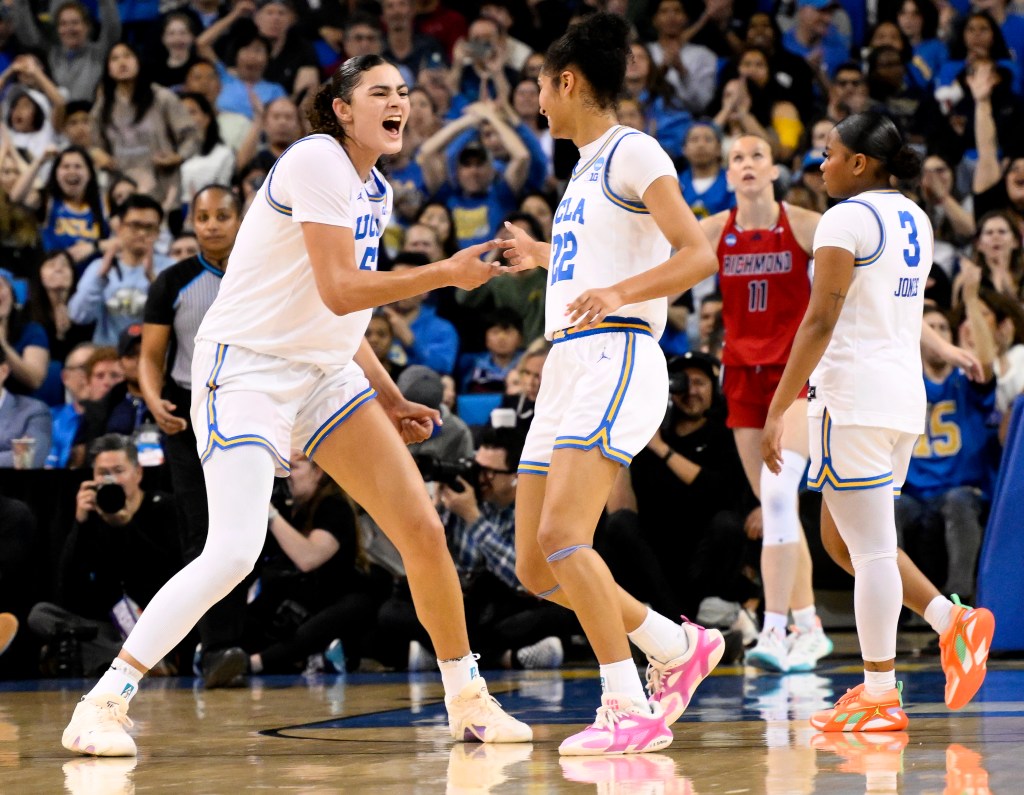 Lauren Betts (left) celebrates with Kendall Dudley after scoring a basket.
