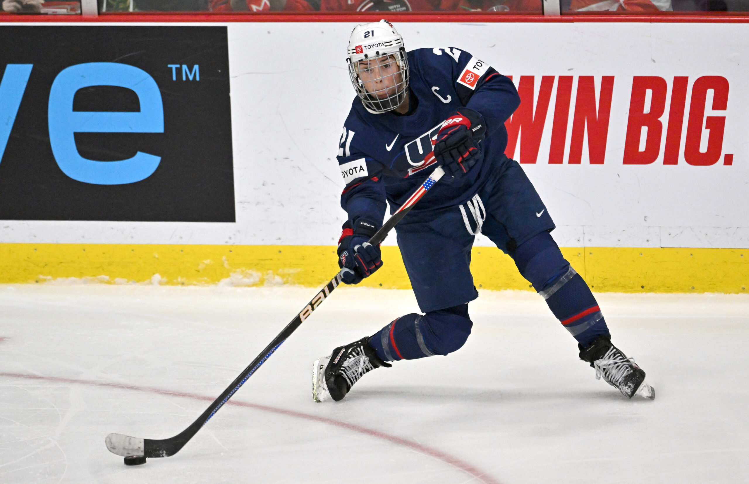 Hilary Knight, wearing Team USA jersey, shoots the puck