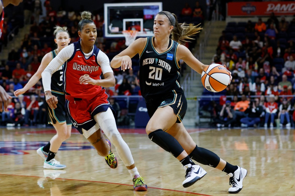 Sabrina Ionescu drives with the basketball while Natasha Cloud guards her