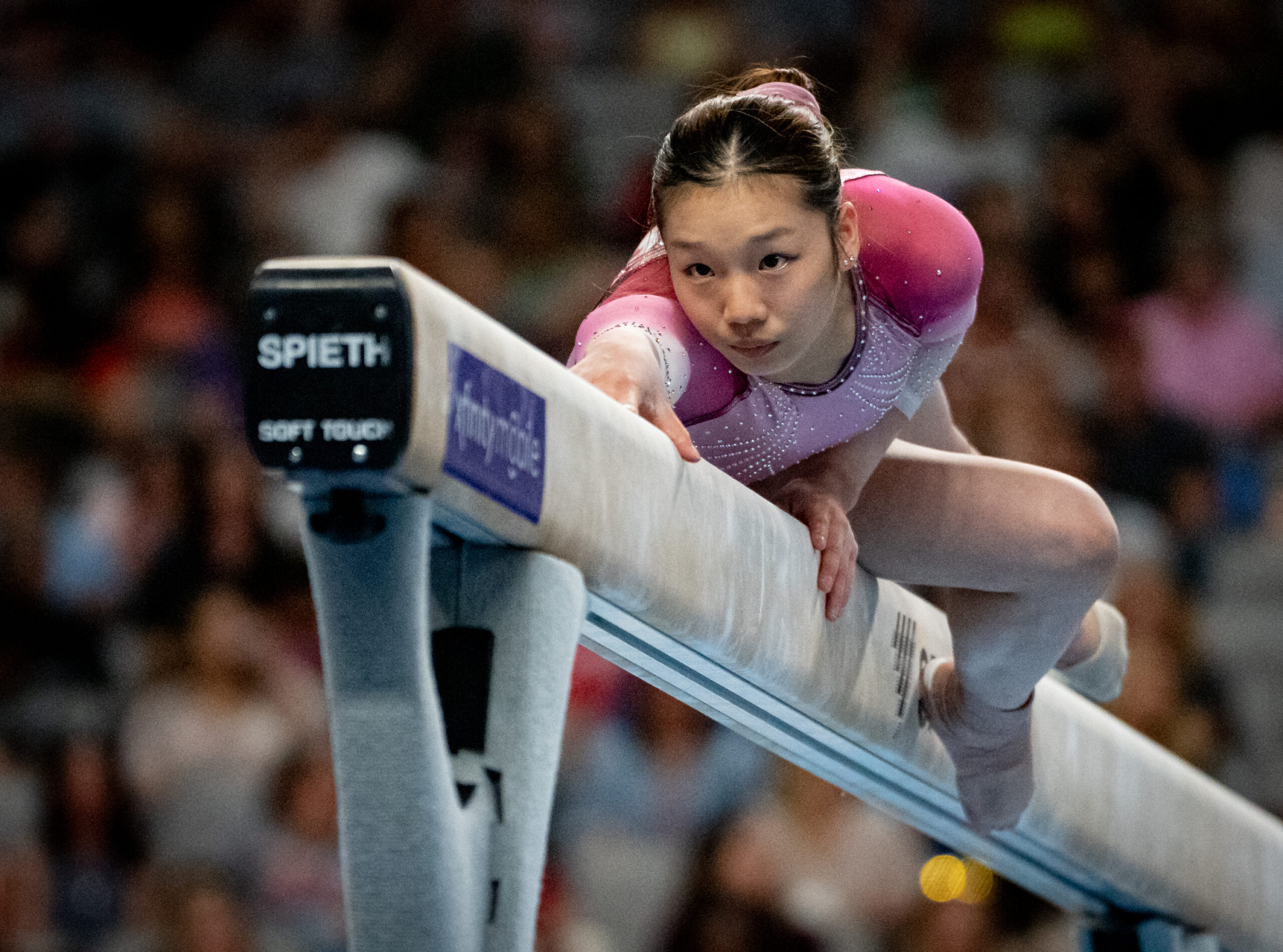 Katelyn Jong wears a pink and white leotard for a routine on balance beam.