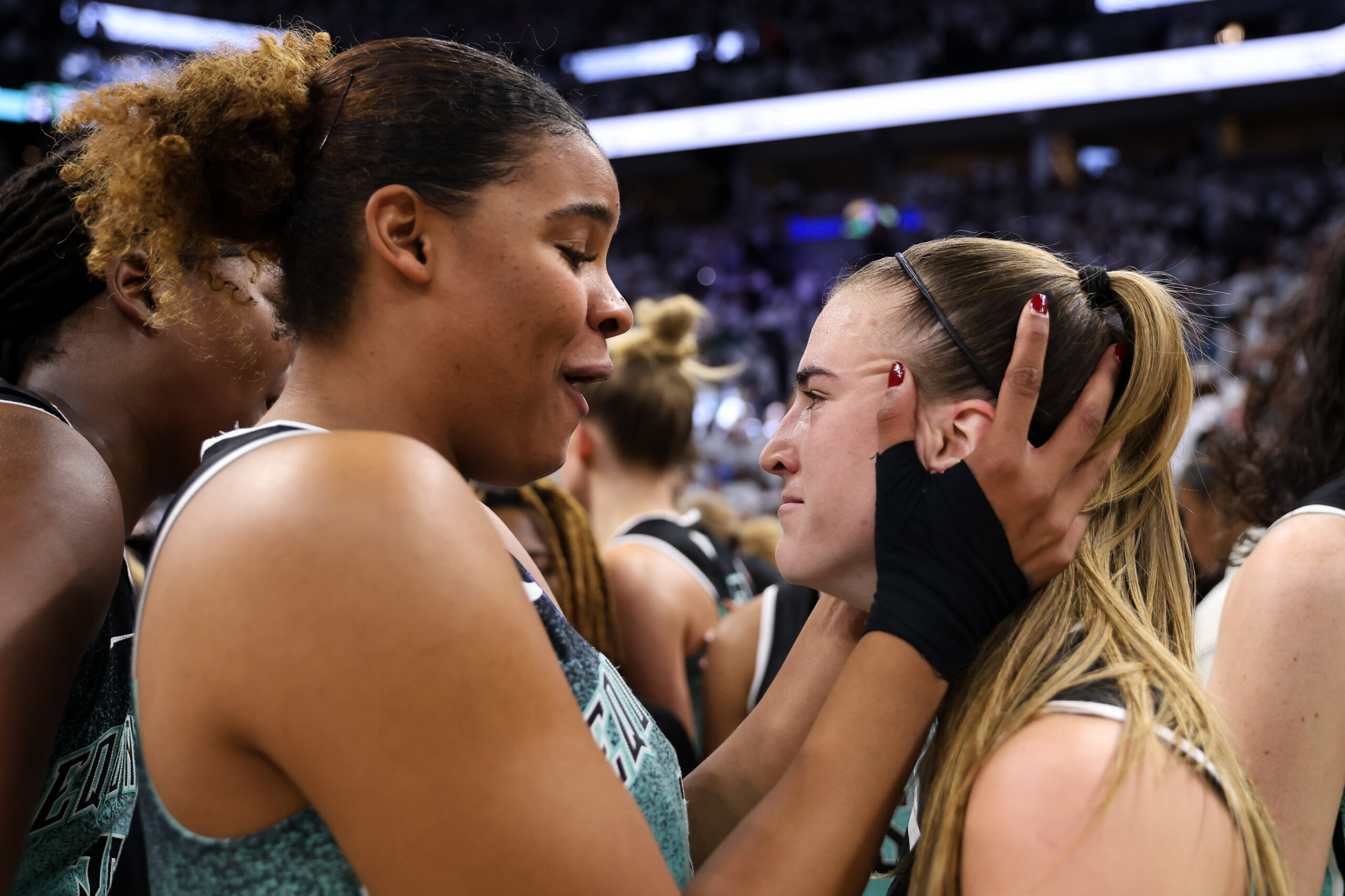 Nyara Sabally holds Sabrina Ioenscu's face in celebration after Ionescu made a game winning shot.