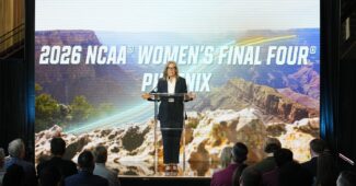 Gov. Hobbs in front of the 2026 NCAA Women's Final Four logo.
