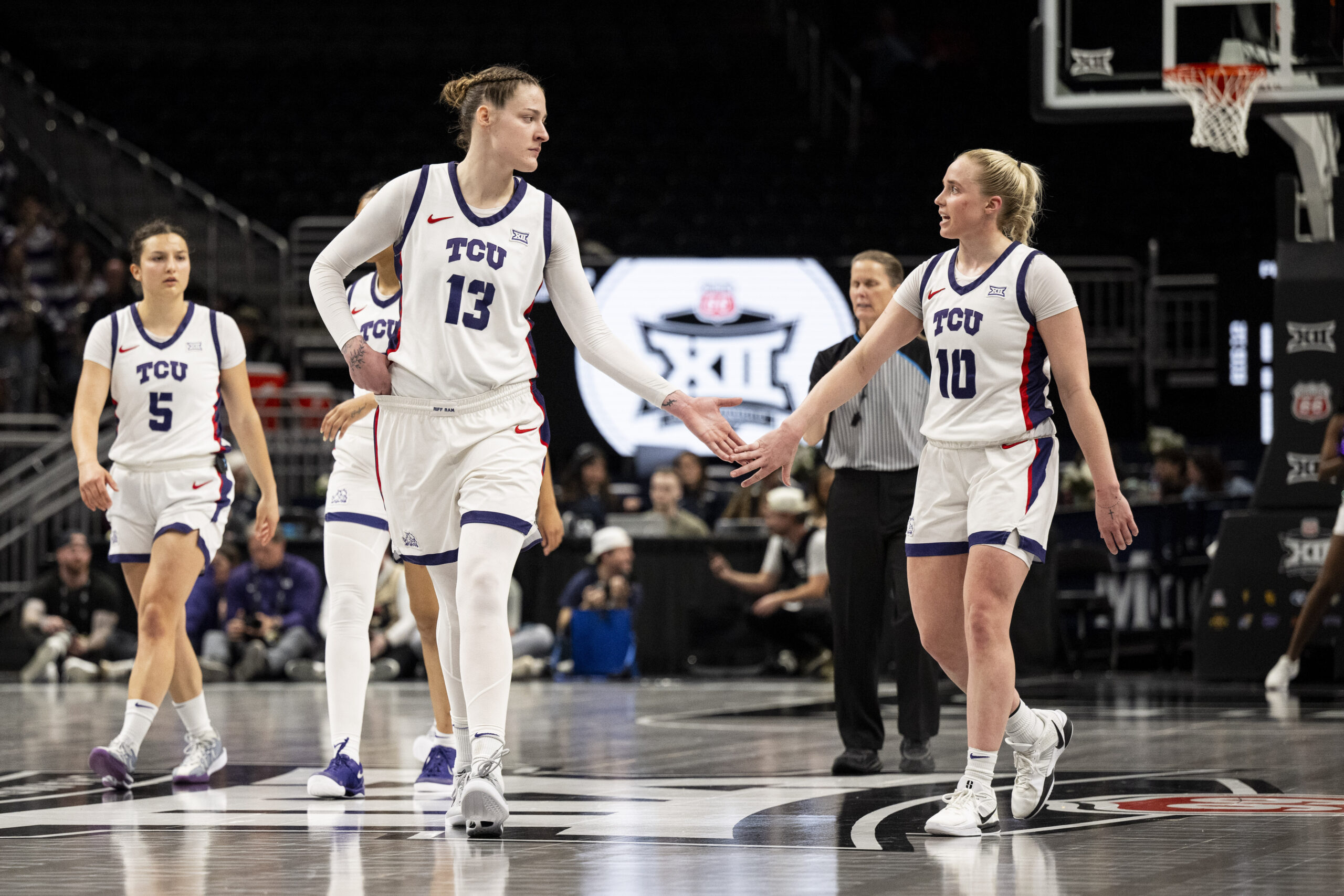 TCU center Sedona Prince and guard Hailey Van Lith high-five while walking down the court.