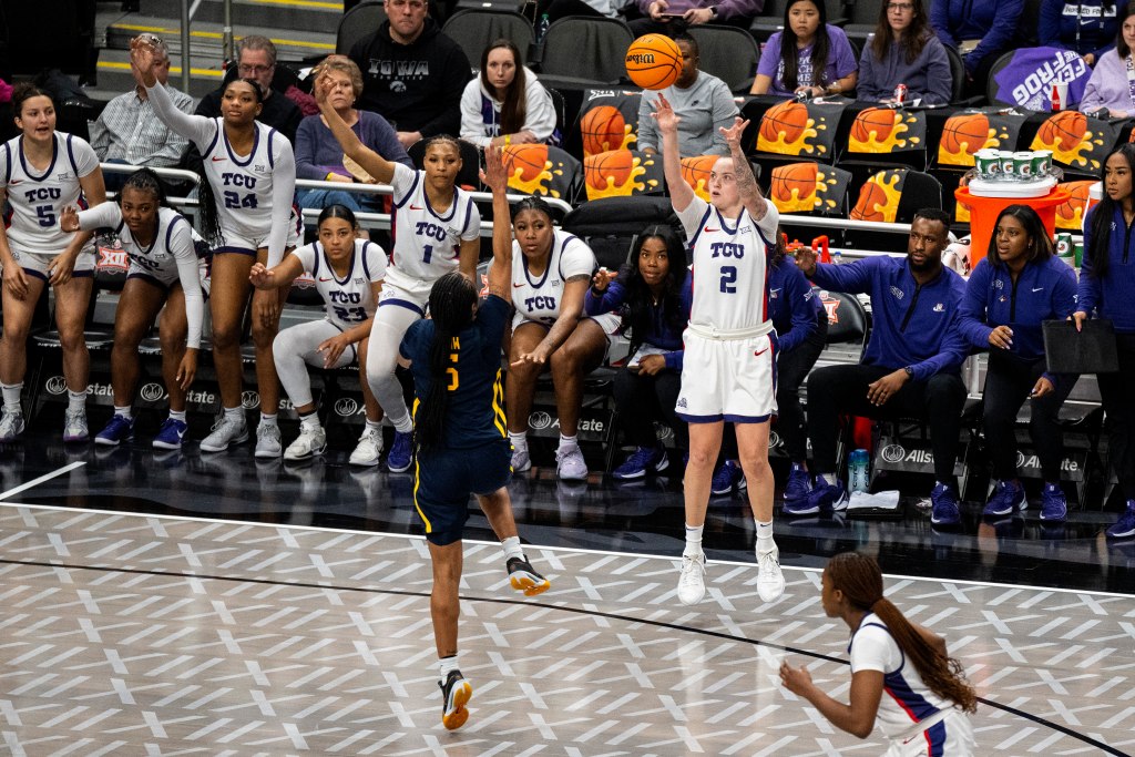 TCU Horned Frogs guard Madison Conner (2) shoots a three pointer while Mountaineers guard Sydney Shaw (5) jumps with her right arm up to contest it