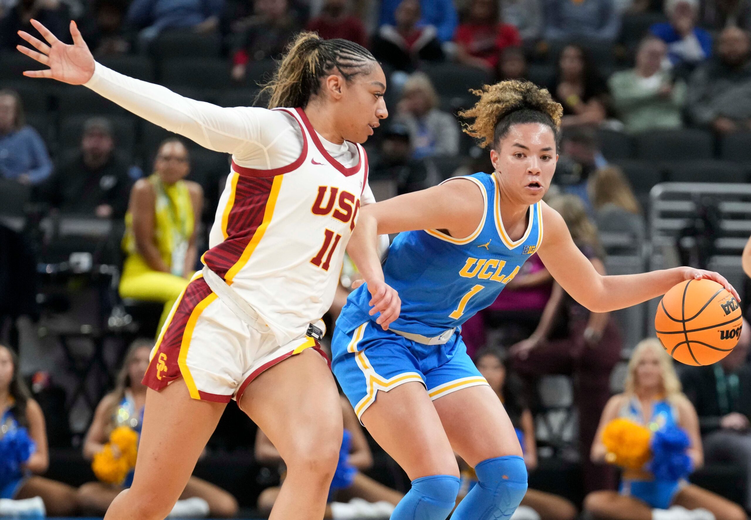 USC's Kennedy Smith runs with UCLA's Kiki Rice as Rice dribbles the ball with her left hand. Rice has her right elbow up as Smith stays on her right hip.
