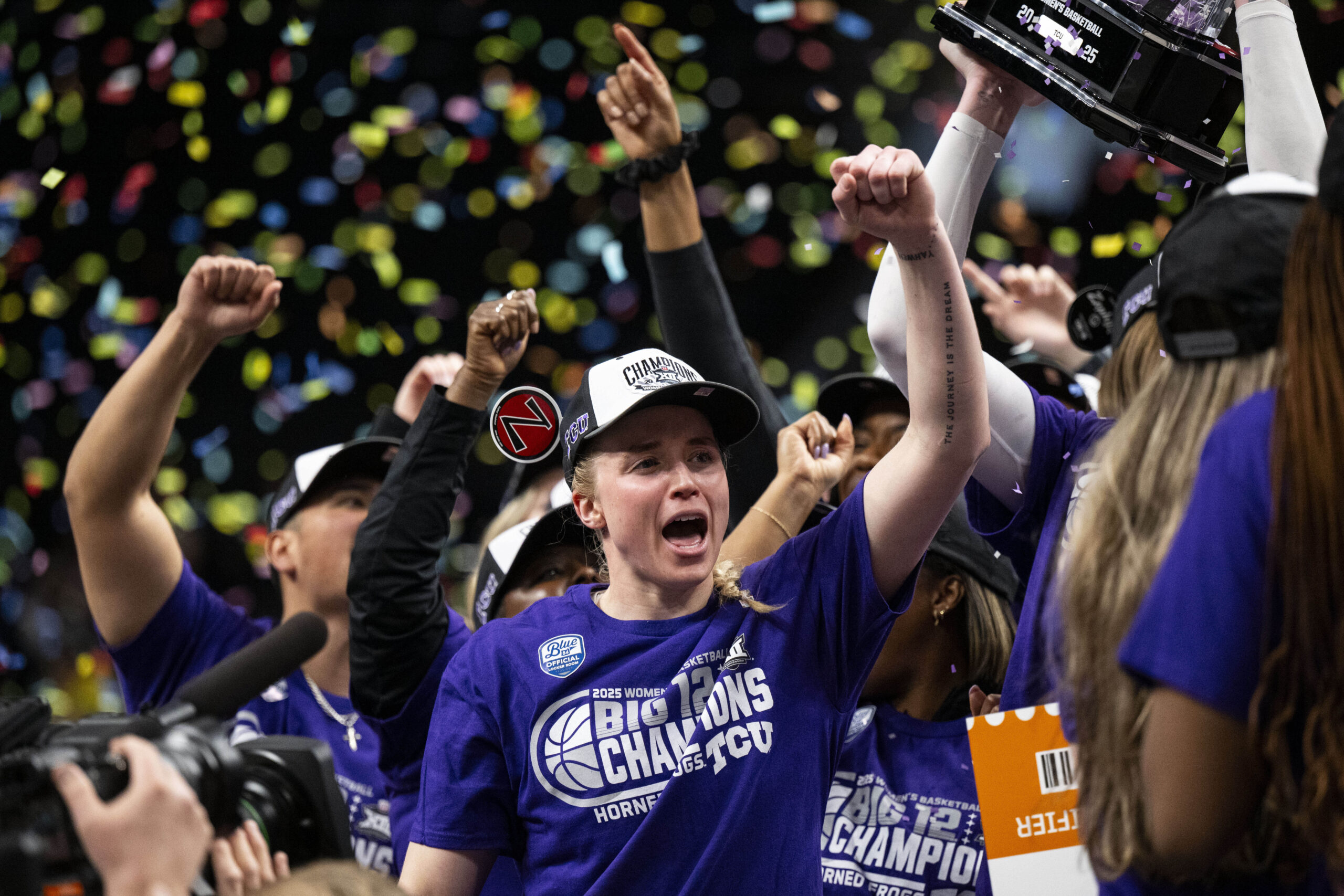 TCU Horned Frogs guard Hailey Van Lith (10) celebrates after with her arm up and confetti falling