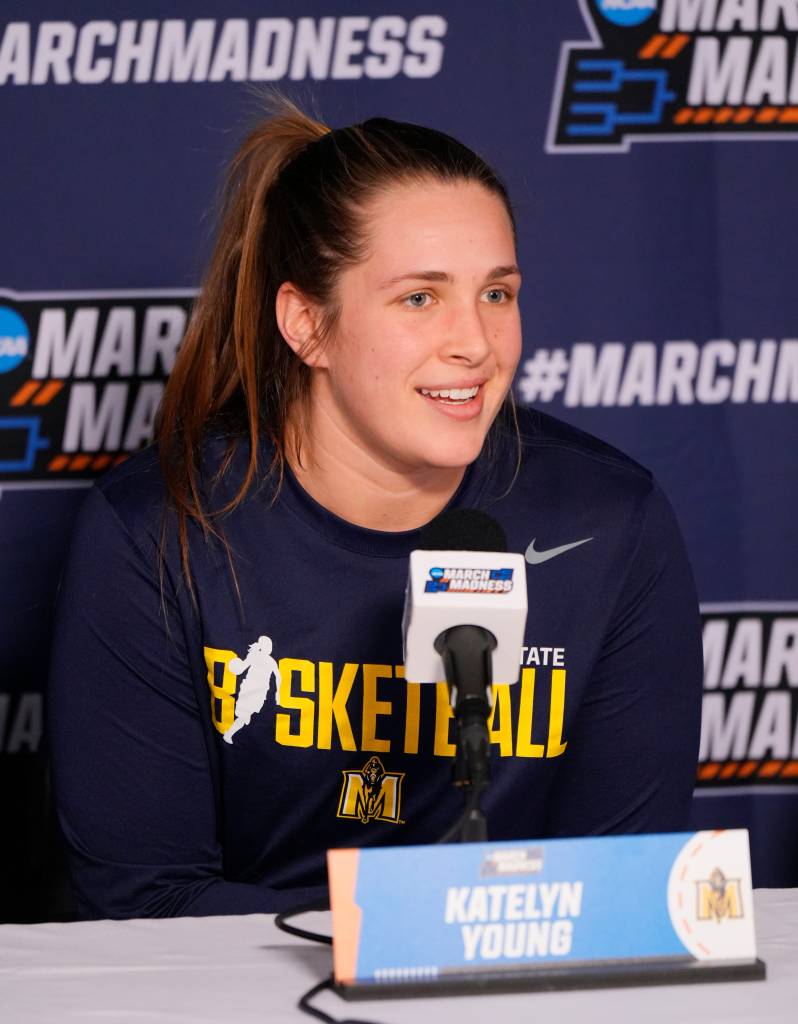 Katelyn Young speaks into a microphone at a press conference