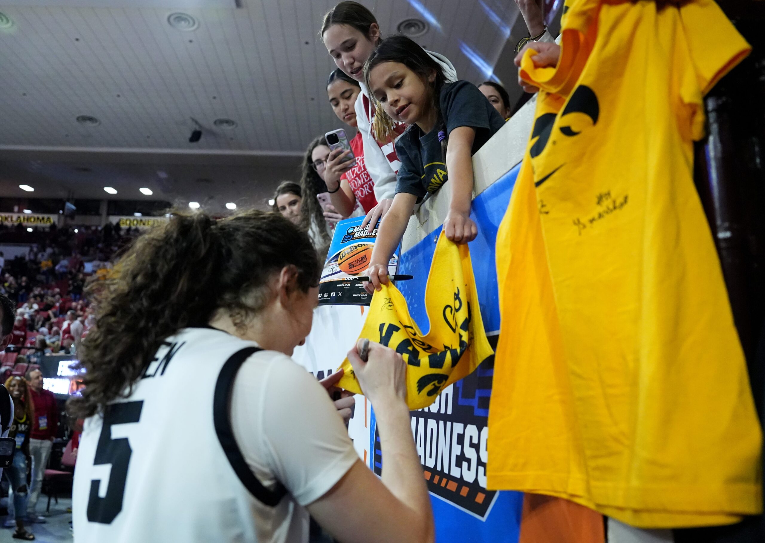Iowa center Ava Heiden signs autographs for young Hawkeye fans.