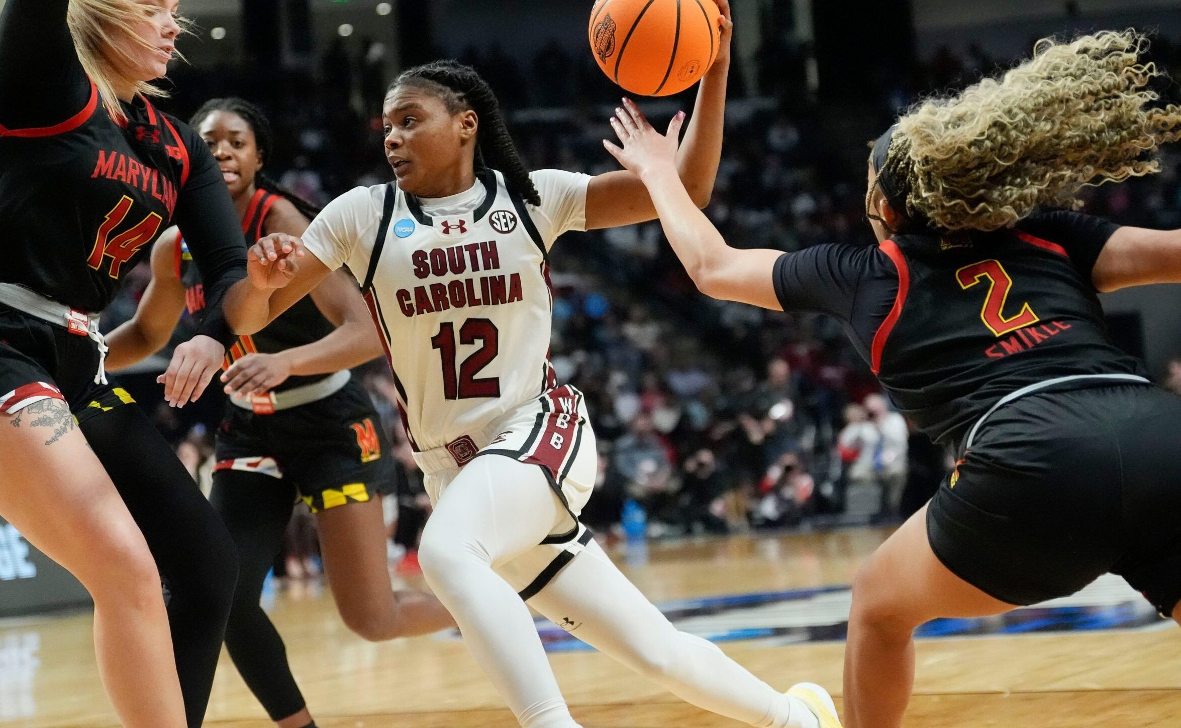 South Carolina guard MiLaysia Fulwiley drives to the rim as Maryland forward Allie Kubek slides her feet to try to contain her and guard Kaylene Smikle reaches toward Fulwiley from the perimeter.