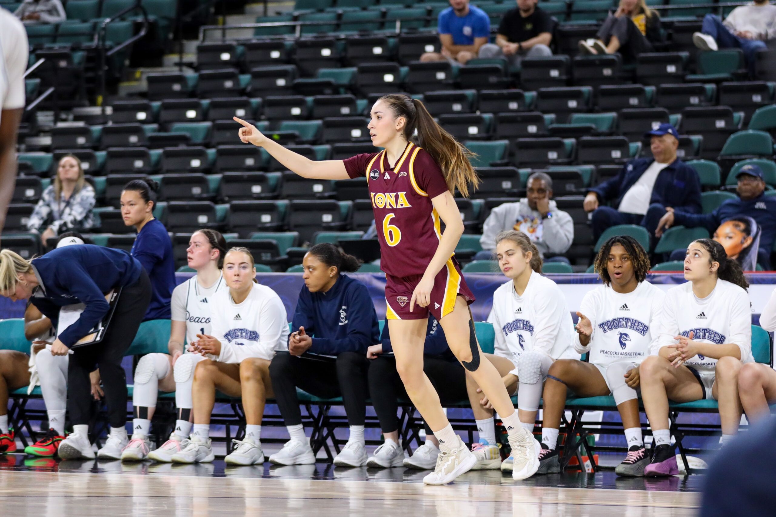 Iona senior guard Judith Gomez looks and points up court while in front of the Iona bench (Photo credit: Will Quincy - Iona Athletics).