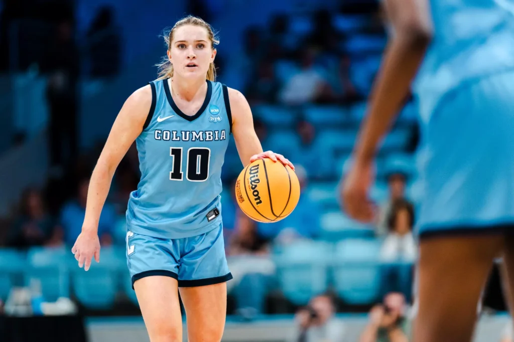 Columbia guard Kitty Henderson dribbles the ball with her left hand without a defender near her and looks straight ahead.