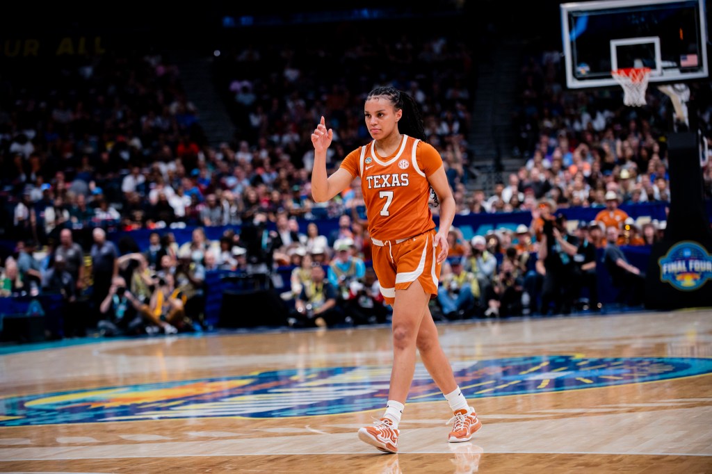 Texas guard Jordan Lee walks across the 3-point line. She has her right hand raised and is looking straight ahead.