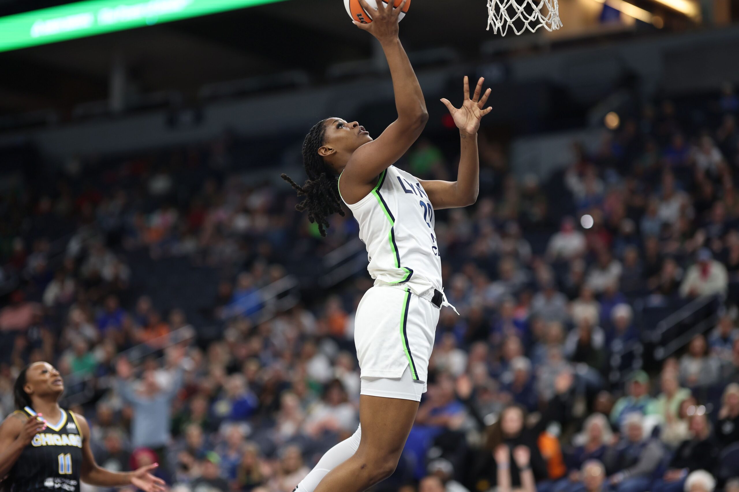 Camryn Taylor (center) shoots the basketball in the foreground