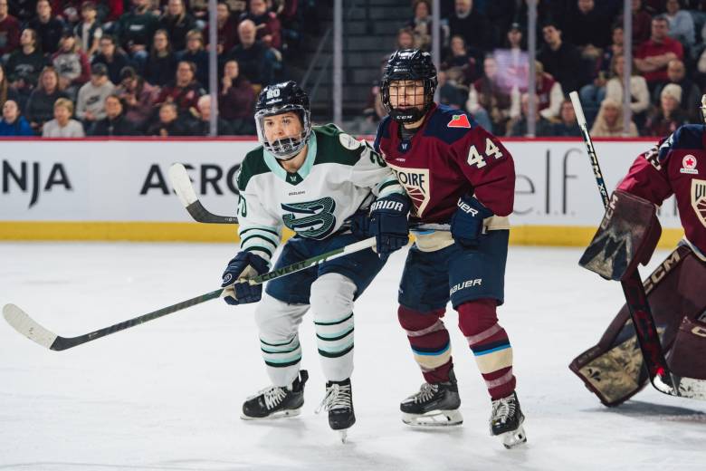 Brandt (left in white) and Boulier (right in maroon) battle for positioning just outside the crease.