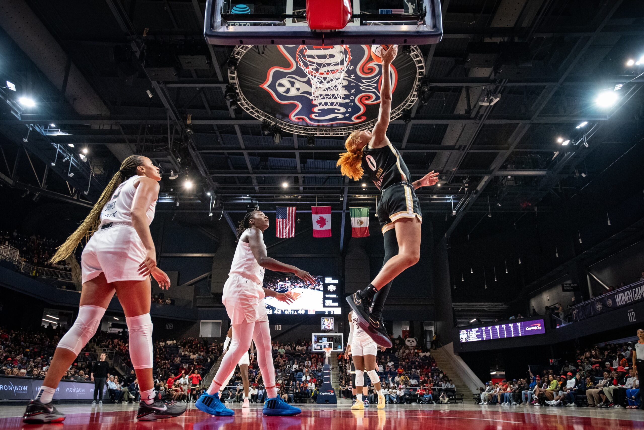 Washington Mystics center/forward Shakira Austin looks up as she shoots a right-handed reverse layup. Two Atlanta Dream defenders stand in the paint and watch Austin, too far away to be able to disrupt the shot.
