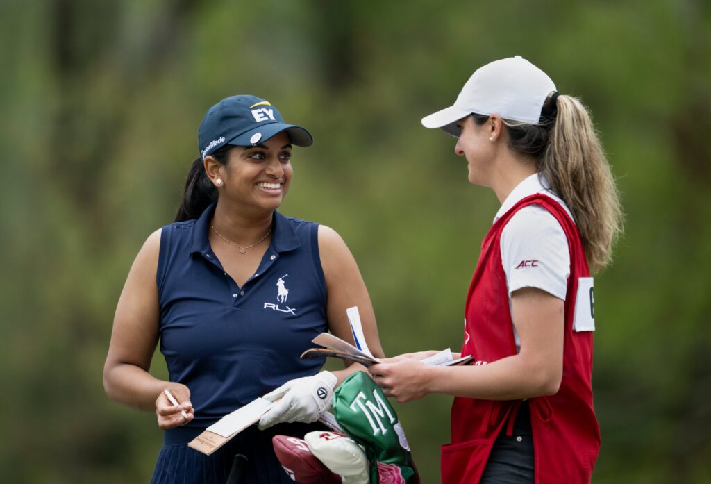 Megha Ganne smiles with her caddie as she takes a score down