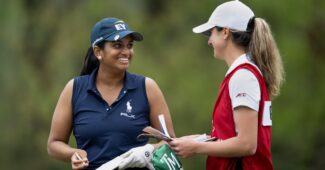 Megha Ganne smiles with her caddie as she takes a score down