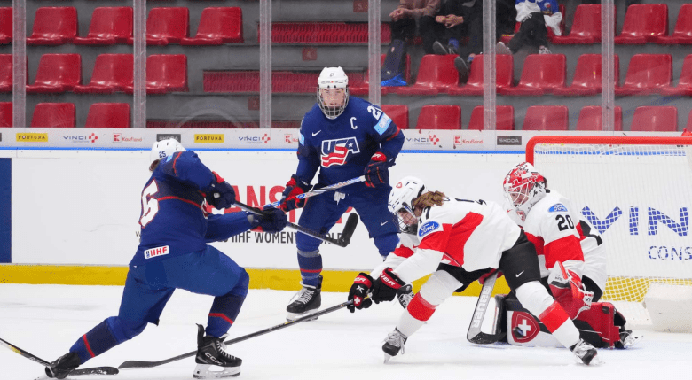 Carpenter follows through on her shot while Knight watches in the background. They are wearing blue USA uniforms.
