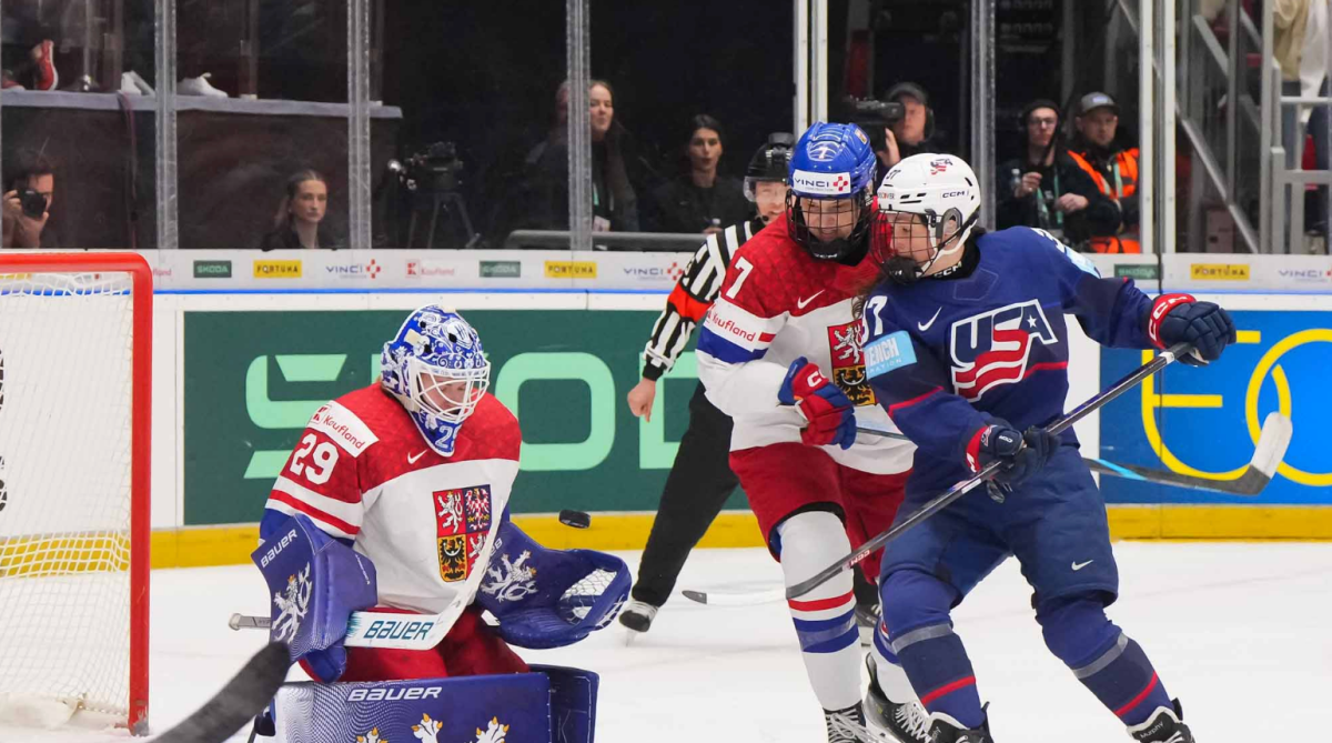 Murphy and Seroiszková battle out front as Peslarová makes a save. The Czech players are in white, Murphy in blue.