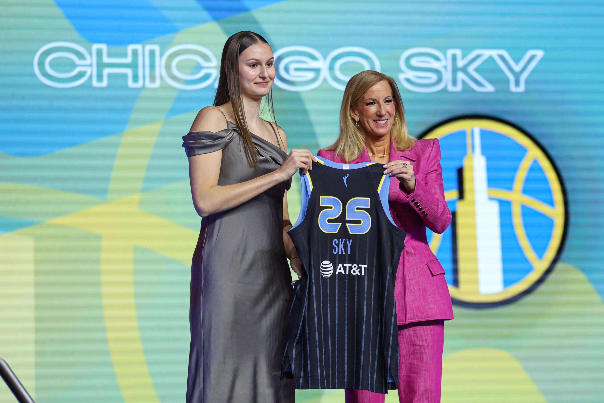Ajsa Sivka and Cathy Engelbert hold up a jersey while posing for pictures